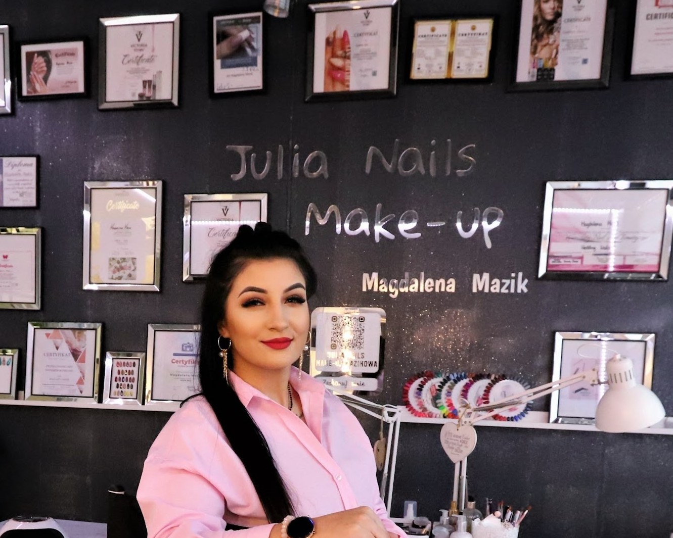 Magdalena Mazik in haar salon, voor de wand met haar certificaten en de naam Julia Nails Make-up