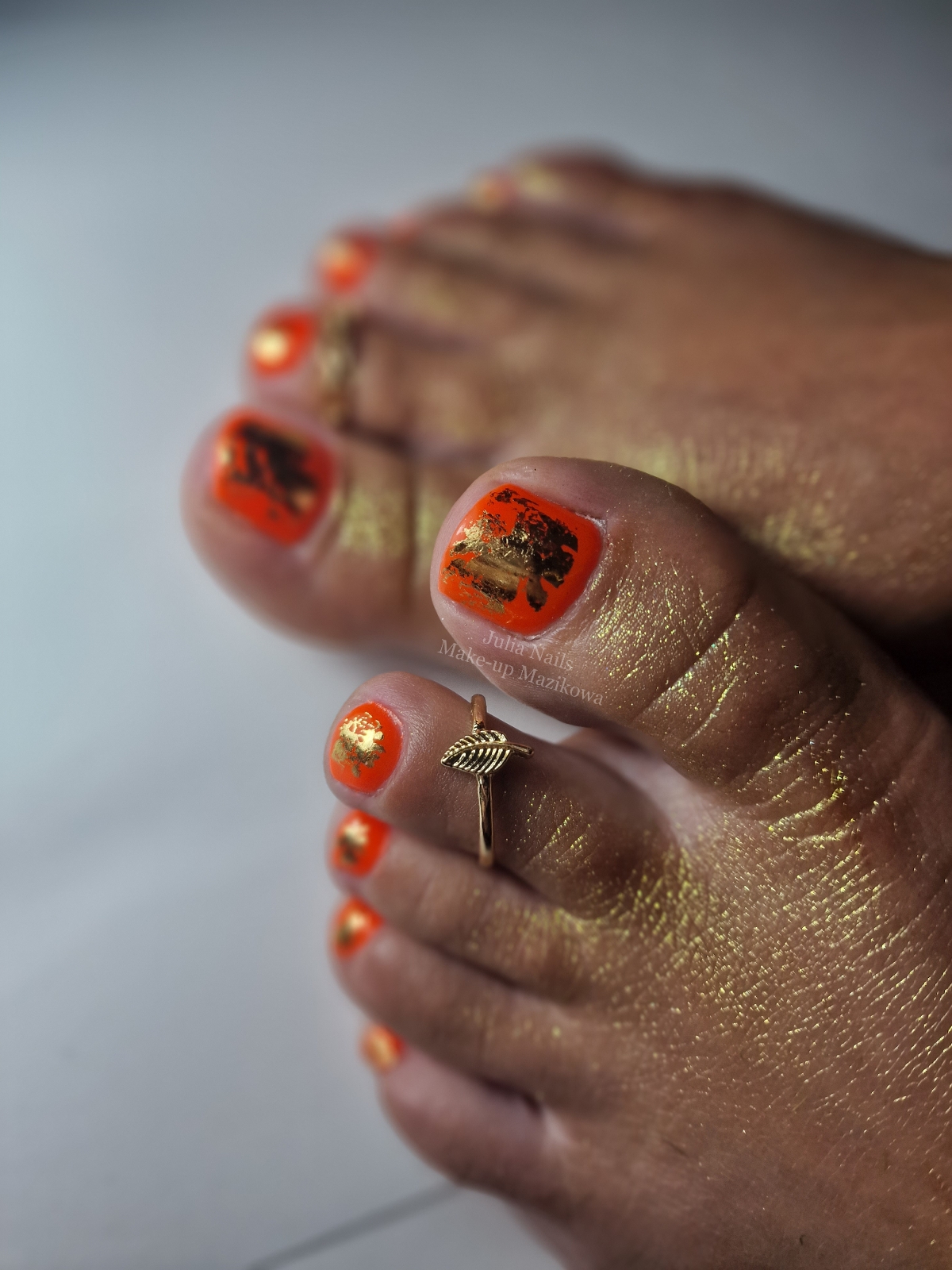 Oranje gellak pedicure met goudfolie en een teenring